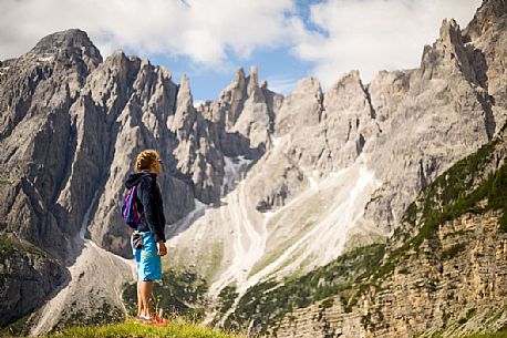 A young hiker looks the Popera group in the Sesto Dolomites from Forcella Pian della Biscia, Comelico, Italy