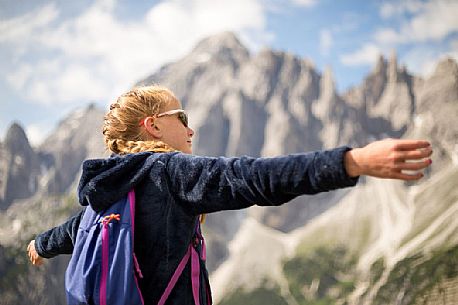 A young hiker looks the Popera group in the Sesto Dolomites from Forcella Pian della Biscia, Cadore, Italy