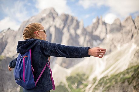 A young hiker looks the Popera group in the Sesto Dolomites from Forcella Pian della Biscia, Cadore, Italy