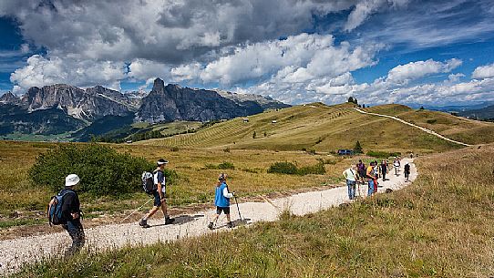 Hikers along the path of Pralongi meadows, Badia Valley, South Tyrol, Dolomites, Italy