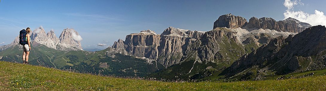 Hiker is admiring Sella and Sassolungo mountain from Belvedere hut, Canazei, Fassa Valley, Dolomites, Italy
 