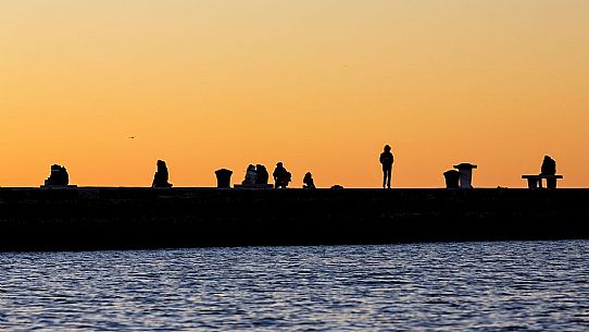 People on the Molo Audace at sunset, Trieste, Italy