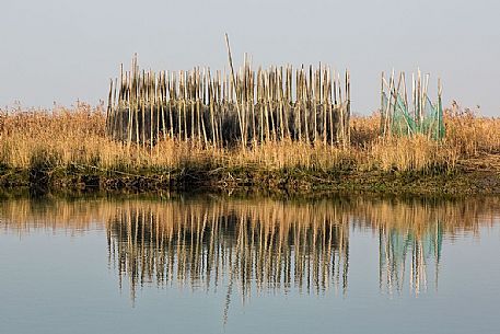 Traditional fishing nets spread out to dry on the shore, Marano Lagunare, Italy