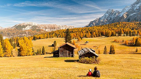 Mother and child admiring the Dolomite's autumn landscape, Prati dell'Armentara, Sasso della Croce mountain group in background, Badia Valley, Italy, Fanes Senes Braies Natural Park Mother and child admiring the Dolomite's autumn landscape, Prati dell'Armentara, Sasso della Croce mountain group in background, Badia Valley, Italy, Fanes Senes Braies Natural Park