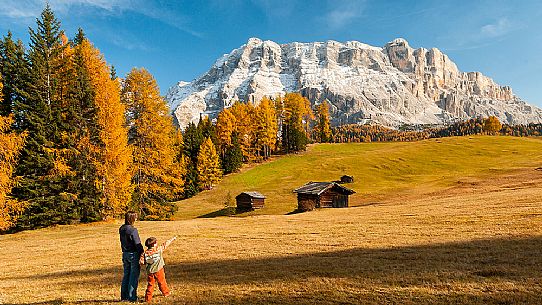 Mother and child admiring the Dolomite's autumn landscape, Prati dell'Armentara, Sasso della Croce mountain group in background, Badia Valley, Italy, Fanes Senes Braies Natural Park 