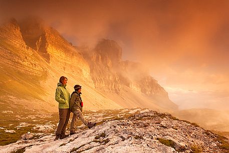 Hikers are looking the sunrise to dolomites of Brenta from Grost pass, Trentino, Italy