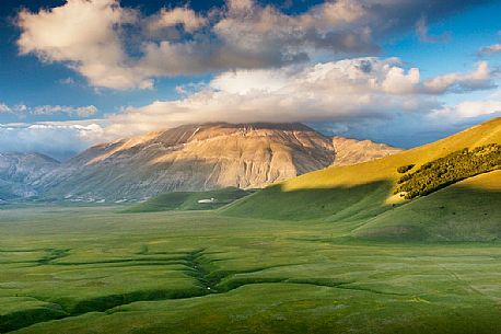 Last lights on Piano Grande Plateau with visible the karst Fosso dei Mergani and in the background Vettore Mount and its fault, Sibillini National Park, Italy