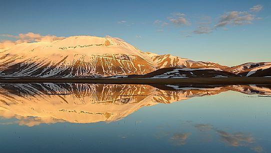 Thaw on the Pian Grande of Castelluccio di Norcia, in the background the Vettore mountain, Sibillini National Park