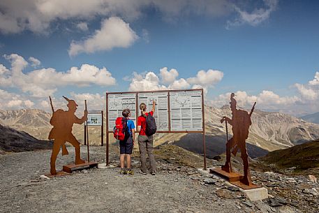 Hikers at Garibaldi peak or Dreisprachenspitze, in the background the swiss alps, Stelvio pass, Stelvio national park, Italy