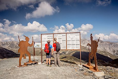 Hikers at Garibaldi peak or Dreisprachenspitze, in the background the swiss alps, Stelvio pass, Stelvio national park, Italy