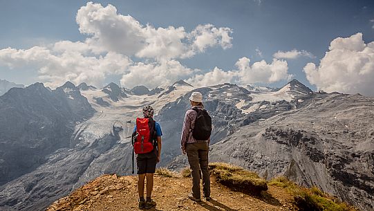 Hikers near Passo dello Stelvio pass and in the background the Stelvio glacier, Passo dello Stelvio national park, Italy Hikers near Passo dello Stelvio pass and in the background the Stelvio glacier, Passo dello Stelvio national park, Italy