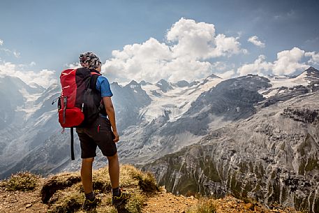 Young hiker near Passo dello Stelvio pass and in the background the Stelvio glacier, Passo dello Stelvio national park, Italy Young hiker near Passo dello Stelvio pass and in the background the Stelvio glacier, Passo dello Stelvio national park, Italy