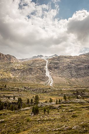 Along the glacier path of the Martello valley, in the background the waterfall and Vedretta Alta peak, Stelvio national park, Italy Along the glacier path of the Martello valley, in the background the waterfall and Vedretta Alta peak, Stelvio national park, Italy