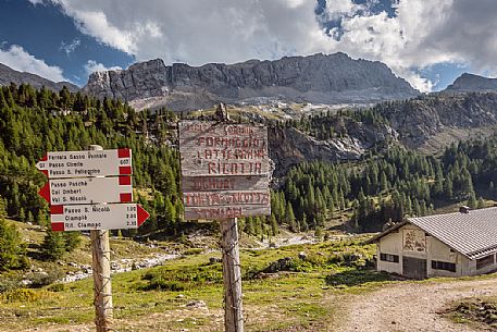 Contrin alm and signs for trekking to the Marmolada group, dolomites, italy
