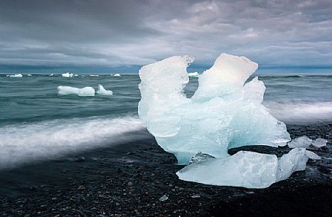 Blue iceberg on black volcanic beach, Jokulsarlon lagoon, Iceland