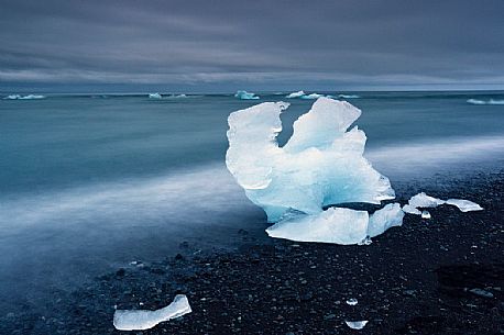 Blue iceberg on black volcanic beach, Jokulsarlon lagoon, Iceland