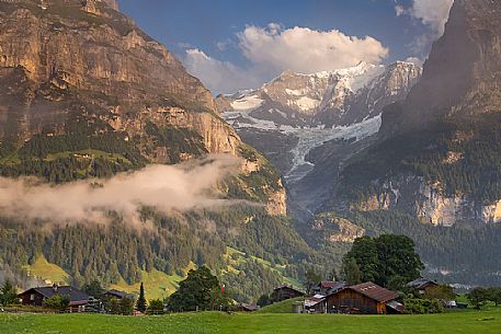 Sunset on Eiger and Fiescherhorn mountain, in foreground typical houses of Grindelwald, Berner Oberland, Switzerland, Europe