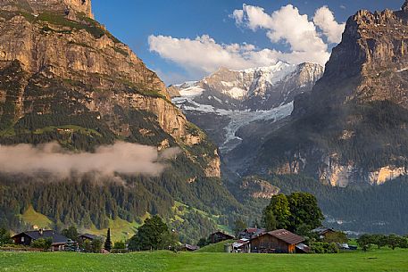 Sunset on Eiger and Fiescherhorn mountain, in foreground typical houses of Grindelwald, Berner Oberland, Switzerland, Europe