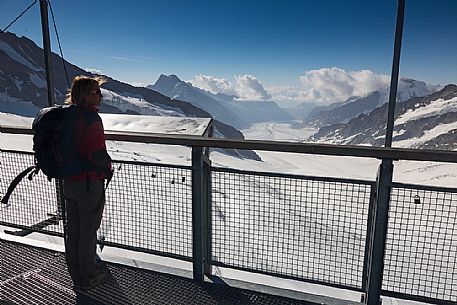 Tourist admiring the Aletsch glacier from the terrace of Sphinx Observatory, Jungfrau Plateau, Top of Europe, Bernese Oberland, Switzerland, Europe