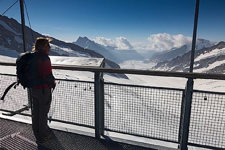 Tourist admiring the Aletsch glacier from the terrace of Sphinx Observatory, Jungfrau Plateau, Top of Europe, Bernese Oberland, Switzerland, Europe Tourist admiring the Aletsch glacier from the terrace of Sphinx Observatory, Jungfrau Plateau, Top of Europe, Bernese Oberland, Switzerland, Europe