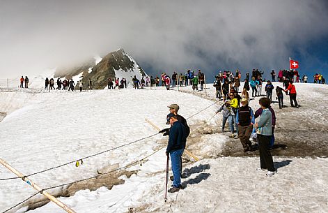 Tourists on the Top of the Jungfraujoch or Top of Europe admiring the Aletsch glacier, the largest in Europe, Bernese alps, Switzerland, Europe Tourists on the Top of the Jungfraujoch or Top of Europe admiring the Aletsch glacier, the largest in Europe, Bernese alps, Switzerland, Europe