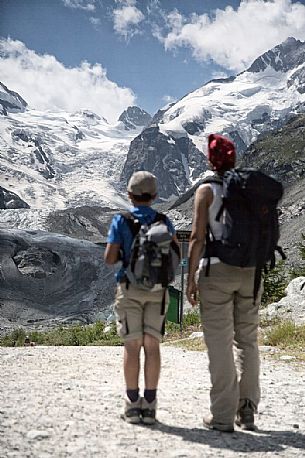 Hiking in Val Morteratsch valley, in the backgrond the glacier and the Bernina mountain range, Pontresina, Engadine, Canton of Grisons, Switzerland, Europe