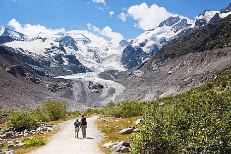 Hiking in Val Morteratsch valley, in the backgrond the glacier and the Bernina mountain range, Pontresina, Engadine, Canton of Grisons, Switzerland, Europe