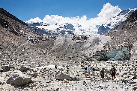 Tourists admiring the Morteratsch Glacier in Val Morteratsh with Bernina mountain group in the background, Pontresina, Engadin, Grisons, Switzerland, Europe
 