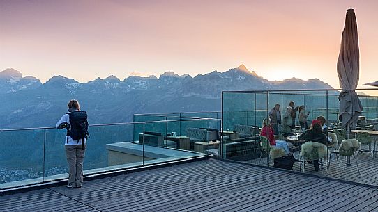 Young woman looking the valley of Saint Moritz at dusk from Romantik Hotel, Muottas Muragl, Samedan, Engadin, Canton of Grisons, Switzerland, Europa