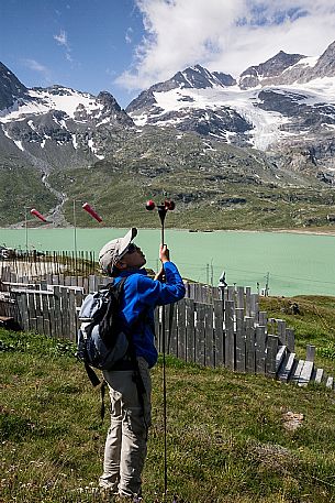 Child playing with the anemometer near Bernina Pass, in the background the Berninamountain group and the Lago Bianco lake, Engadin, Canton of Grisons, Switzerland, Europe
 