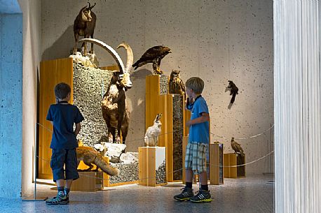 Children listening to audioguide at museum of Swiss National Park in Zernez, Engadin, canton of Grisons, Switzerland, Europe