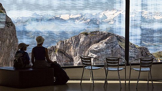 Tourists silhouette looking the panorama of mountains of the Bernese Oberland from summit station of Pilatus Cogwheel Railway , Lucerne, Border Area between the Cantons of Lucerne, Nidwalden and Obwalden, Switzerland, Europe