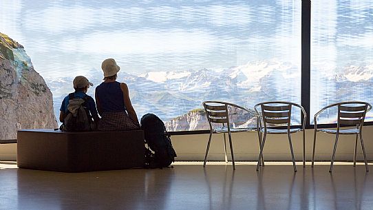 Tourists silhouette looking the panorama of mountains of the Bernese Oberland from summit station of Pilatus Cogwheel Railway , Lucerne, Border Area between the Cantons of Lucerne, Nidwalden and Obwalden, Switzerland, Europe