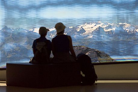 Tourists silhouette looking the panorama of mountains of the Bernese Oberland from summit station of Pilatus Cogwheel Railway , Lucerne, Border Area between the Cantons of Lucerne, Nidwalden and Obwalden, Switzerland, Europe