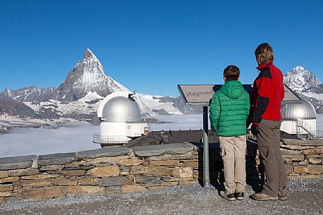 Tourists in the top of Gornergrat, view towards Matterhorn or Cervino mountain and astronomic observatory Klum Hotel, Zermatt, Valis, Switzerland, Europe