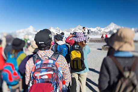 Tourists in the top of Gornergrat admiring the Monte Rosa or Breithorn mountain range , Zermatt, Valis, Switzerland, Europe