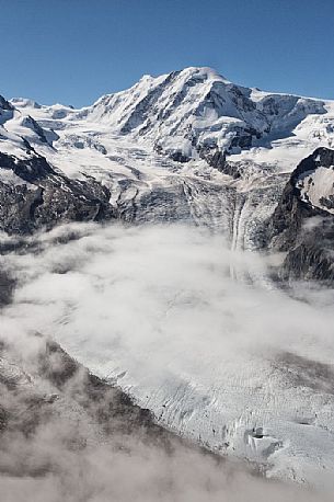 View from Gornergrat mountain towards Monte Rosa or Breithorn mountain range with Liskamm and Gorner Glacier in the clouds, Zermatt, Valais, Switzerland, Europe
 