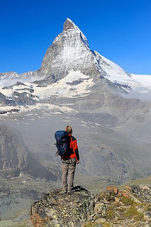 Hiker in the Gornergrat area admiring the Matterhorn or Cervino mount, Zermatt, Valais, Switzerland, Europe