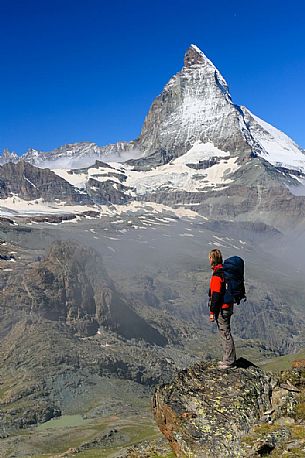 Hiker in the Gornergrat area admiring the Matterhorn or Cervino mount, Zermatt, Valais, Switzerland, Europe