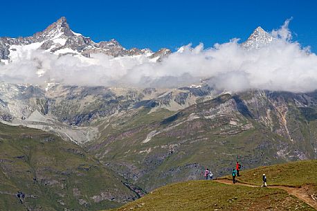 Family of hikers in the path of Gornergrat area near Riffel lake, Zermatt, Valais, Switzerland, Europe