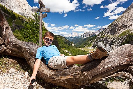Child lying in the old tree near Falier mountain hut, Val Ombretta, Marmolada mountain range, dolomites, Veneto, Italy, Europe