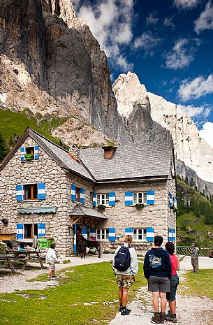 Hikers admiring the south big wall of Marmolada from the Rifugio Falier hut, Val Ombretta, dolomites, Veneto, Italy, Europe Hikers admiring the south big wall of Marmolada from the Rifugio Falier hut, Val Ombretta, dolomites, Veneto, Italy, Europe