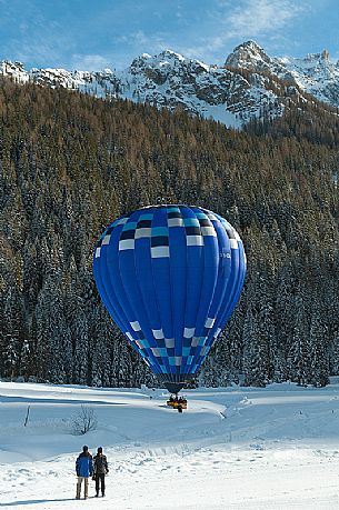 Couple watch the balloon that lands in val Fiscalina during the balloon festival of Dobbiaco, Pusteria valley, dolomites, Trentino Alto Adige, Italy, Europe