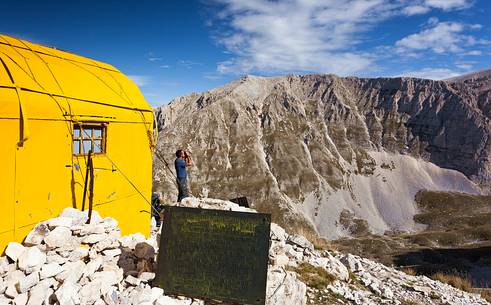 Hiker at the Fusco hut, amphitheater of the Murelle, Majella national park, Abruzzo, Italy, Europe