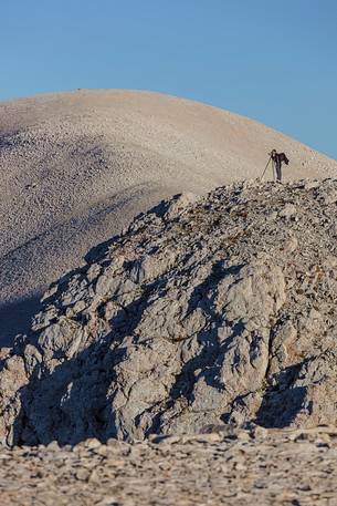 Photographer on the Mount Acquaviva peak in the amphitheater of the Murelle, Majella national park, Abruzzo, Italy, Europe