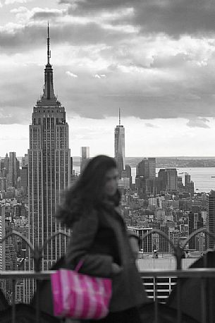 Young woman at the Top the Rock of Rockefeller Center towards Empire State Building, Manhattan, New York City, New York, USA
