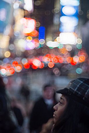 Young woman in Times Square by night, Manhattan, New York, United States