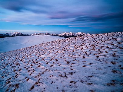 Winter twilight from the top of Pizzoc mount, in the background the peaks of Monte Cavallo mountain range, Cansiglio, Veneto, Italy, Europe
