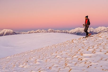 Hiking with snowshoe on the top of Pizzoc mount, in the background the Cavallo mountain range, Cansiglio, Veneto, Italy, Europe