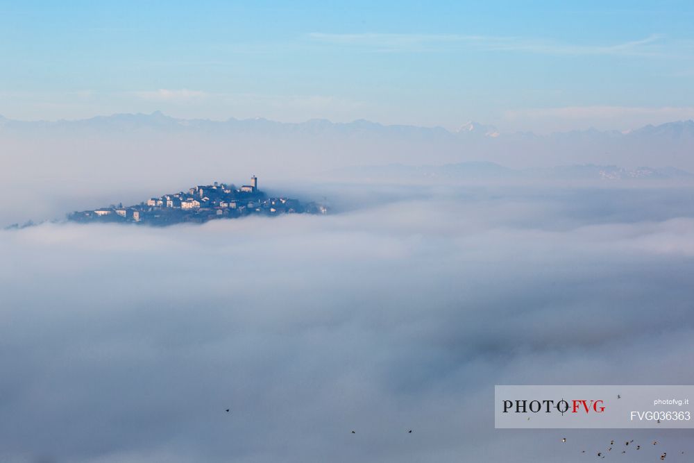 The small village of Conzano Monferrato in the fog, on the background the Alps, Monferrato, Piedmont, Italy, Europe